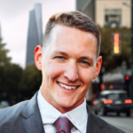 A man in a suit and tie standing on the side of a road.